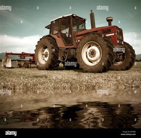 Tractor On Field Near Water Pond Stock Photo Alamy