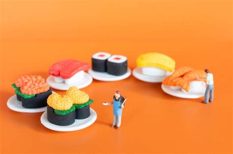 Premium Photo Miniature People Chef Making Sushi Set On Orange