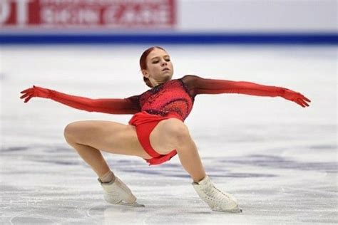 A Woman Skating On An Ice Rink Wearing A Red Outfit And White Shoes