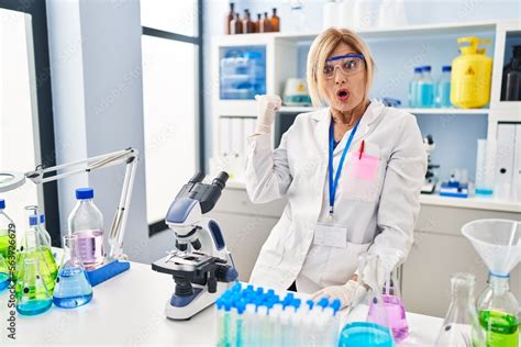 Middle Age Blonde Woman Working At Scientist Laboratory Surprised