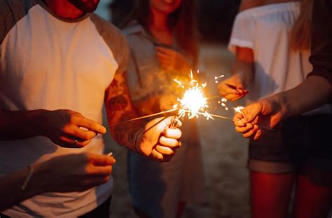 Premium Photo Group Of People Holding Sparklers At Party On The Beach