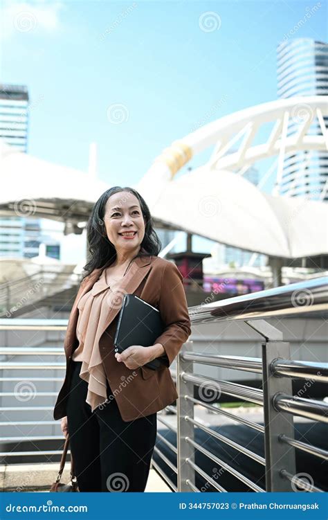 Portrait Of Elegant Mature Businesswoman Standing In The City And Looking Upwards Stock Image
