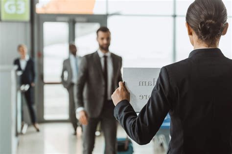 Waiting For Passengers With Name Sign On Paper At Airport Welcome Board