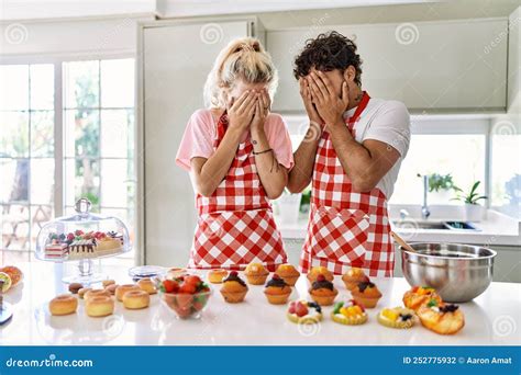 Couple Of Wife And Husband Cooking Pastries At The Kitchen With Sad Expression Covering Face