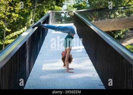 Athletic Pose Of An Attractive Yo Blonde Girl On A Pedestrian Bridge
