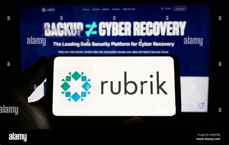 Person Holding Smartphone With Logo Of US Data Security Company Rubrik