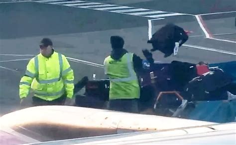 Luggage thrown through air by baggage handlers in video filmed by ...
