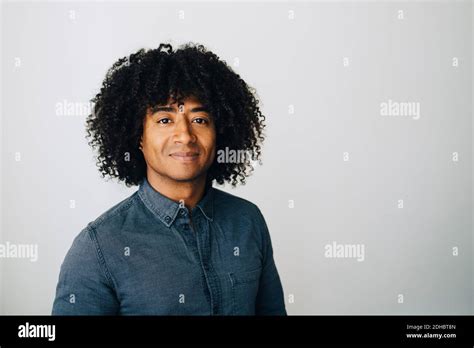 Portrait Of Confident Businessman With Curly Hair Standing Against