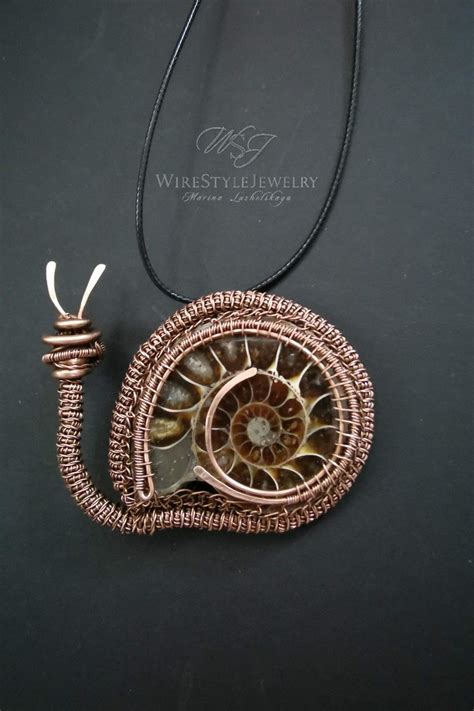 A Necklace Made Out Of Wire With A Pendant Hanging From It S Side On A