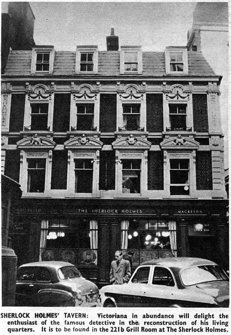 An Old Black And White Photo Of A Building With Cars Parked In Front Of It