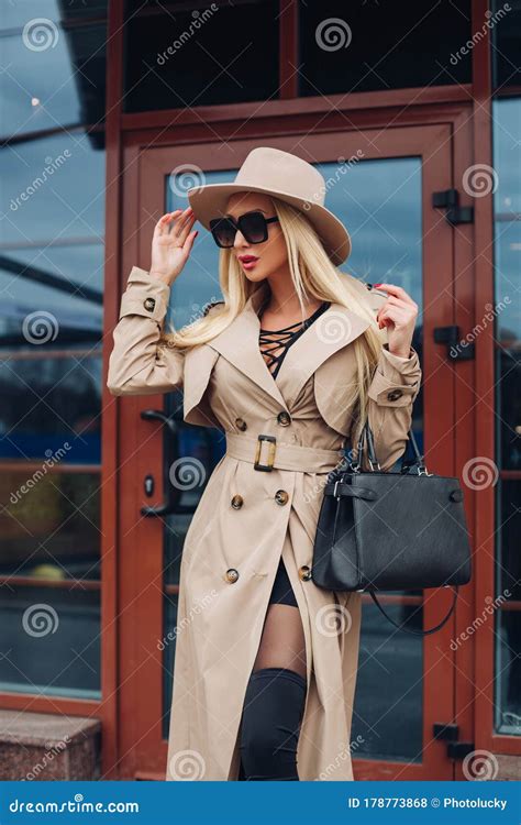 Femme Blonde élégante Dans Le Manteau Et Le Chapeau De Tranchées Photo stock Image du jour