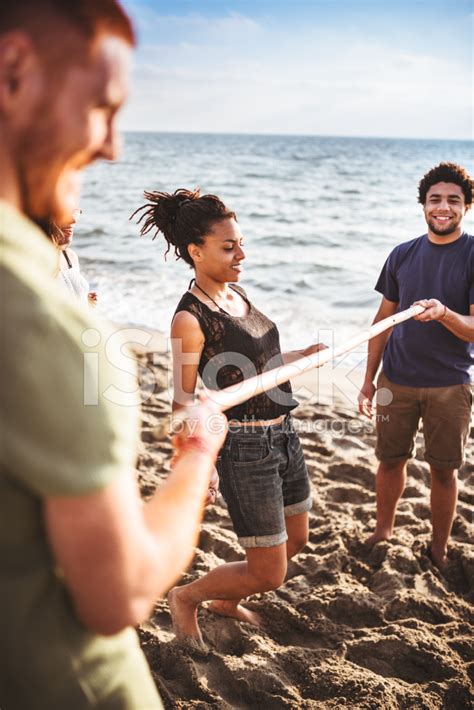 Foto De Stock Amigos Que Juegan En La Playa Limbo Libre De Derechos