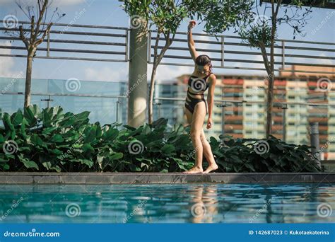 Slim Caucasian Brunette Walking Between Green Bushes And Trees On Edge