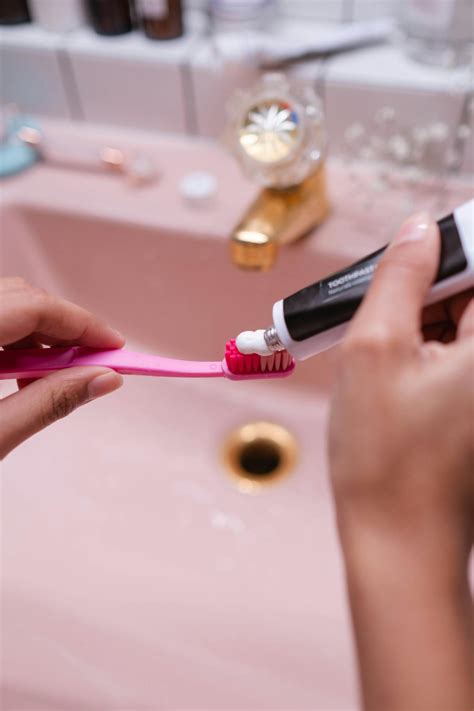 Person Putting Toothpaste On Toothbrush · Free Stock Photo