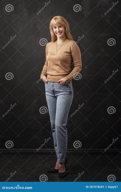 Pleine Longueur De La Femme Blonde Souriante Debout Sur Fond Noir Image Stock Image Du Noir