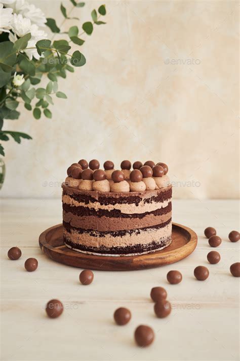 Vertical Shot Of A Delicious Chocolate Naked Cake With Choco Balls And