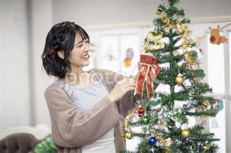 クリスマスツリーの飾りつけをする女性 No 22799867｜写真素材なら「写真ac」無料（フリー）ダウンロードok