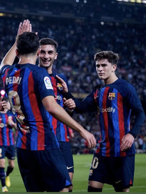 Three Soccer Players Are Congratulating Each Other On The Field