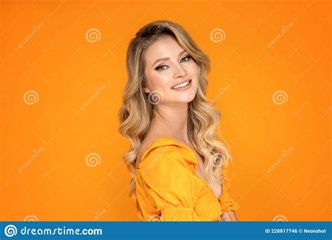 Portrait Of Cute Beautiful Woman With Blonde Long Wavy Hair Looking At The Camera With Happy