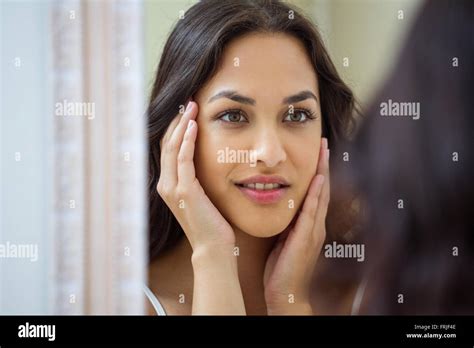 Young Woman Looking In Mirror Of Bathroom Stock Photo Alamy