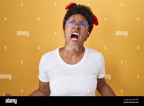 Young African American Woman Standing Over Yellow Background Angry And Mad Screaming Frustrated