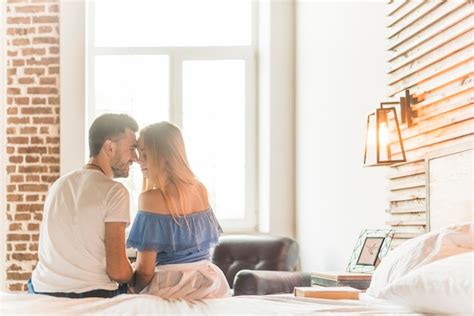 Couple Romantique Sembrasser Sur Le Lit Photo Gratuite