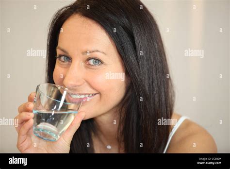 Brunette Drinking A Glass Of Water Stock Photo Alamy