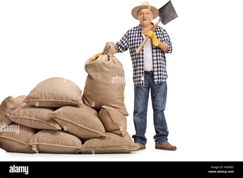 Full Length Portrait Of A Mature Farmer With A Shovel Standing Next To