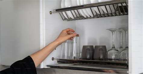 Cropped View Of Woman Hand Taking Clean Glassware From Shelves Housewife Standing On Modern