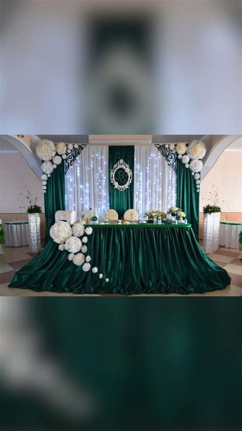 The Table Is Set Up With White Flowers And Greenery For An Elegant