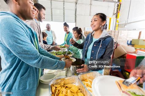 Group Of Volunteers Serve Meal To Homeless People High Res Stock Photo