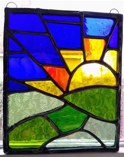 A Close Up Of A Stained Glass Window With The Sun In It S Center