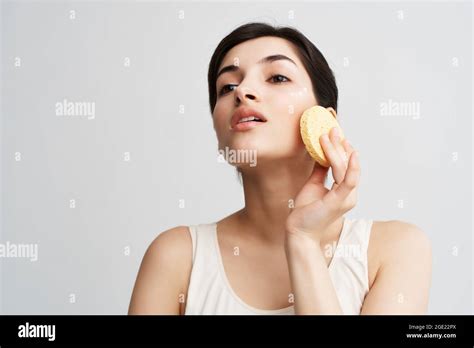Pretty Brunette Applying Makeup With A Sponge On Her Face Stock Photo Alamy