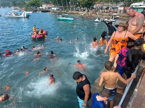 Foliões mergulham fantasiados no tradicional Banho da Dorotéia em