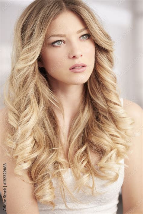 Blonde Girl With Long Curl Hair And Blue Eyes Portrait Stock Photo