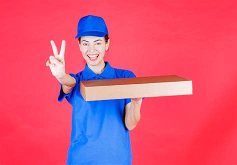 Free Photo Female Courier In Blue Uniform Holding A Cardboard