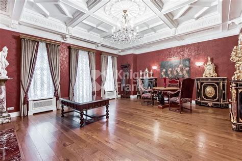 An Ornately Decorated Living Room With Red Walls And Wood Flooring Is