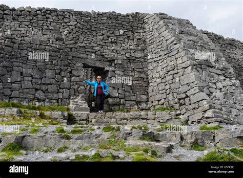 A tourist stands at the entrance to Dun Aonghasa, a prehistoric stone ...