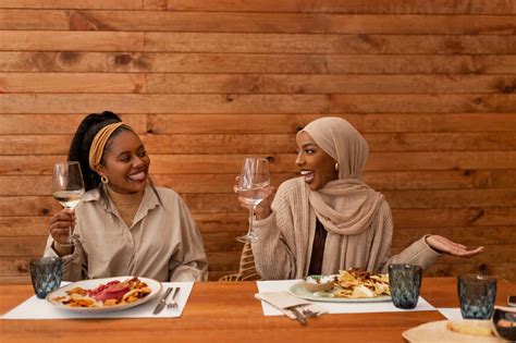 Young Friends Enjoying A Celebratory Lunch In A Restaurant Two Happy