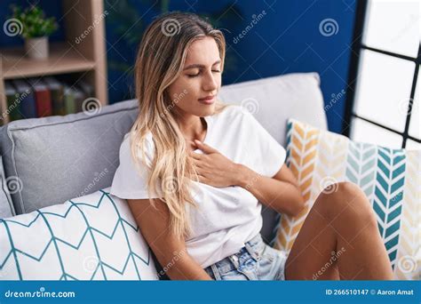 Jeune Femme Blonde Assise Sur Un Canapé Souffrant De Douleur Thoracique Dans La Rue Image stock