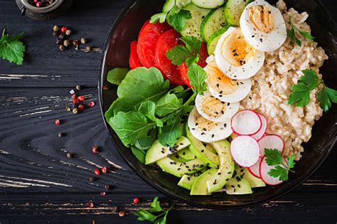 신선한 야채토마토 아보카도 오이 무 계란 Arugula 그릇에 오트밀의 건강 한 샐러드 다이어트 음식입니다 플랫이 하다 상위 뷰