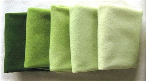 Five Green Towels Lined Up On Top Of Each Other