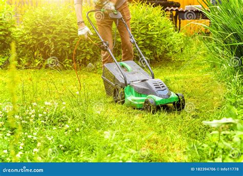 Man Cutting Green Grass With Lawn Mower In Backyard Gardening Country Lifestyle Background