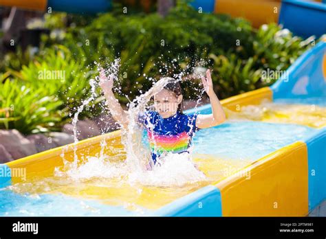 Kids On Water Slide In Aqua Park Children Having Fun On Water Slides