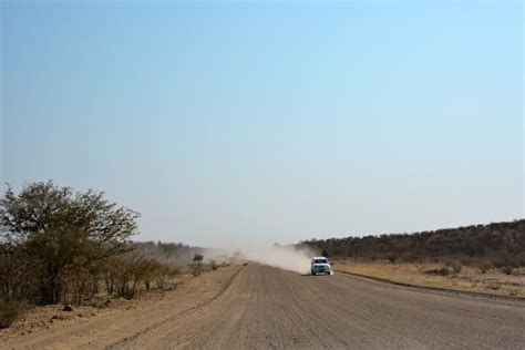 Premium Photo A Car Drives Along A Wide Dirt Road In The Desert In