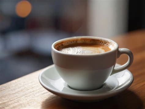 Premium Photo Close Up View Of A Hot Cup Coffee On A Wooden Table With Blurred Background