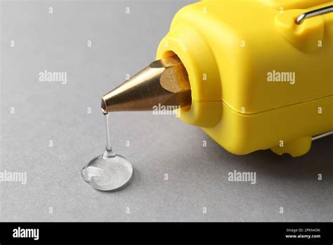 Melted Glue Dripping Out Of Hot Gun Nozzle On Grey Background Closeup Stock Photo Alamy