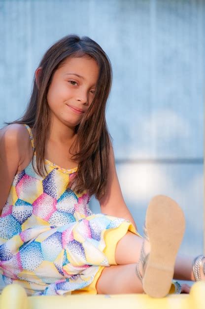 Premium Photo Portrait Of Smiling Girl Sitting In Playground