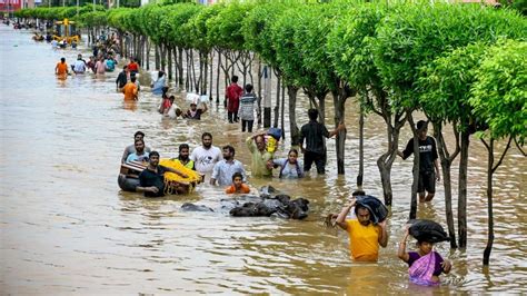 IN PHOTOS People Wade Through Flooded Streets In Vijayawada