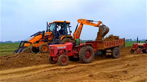 Jcb 3dx Machine Loading Red Mud In Old Mahindra 475 DI Tractor